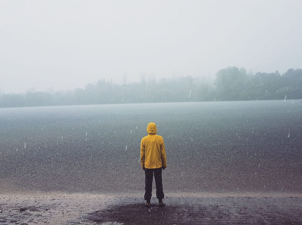 man wearing yellow raincoat during rain